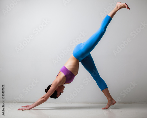 Young beautiful yoga instructor is posing in studio.