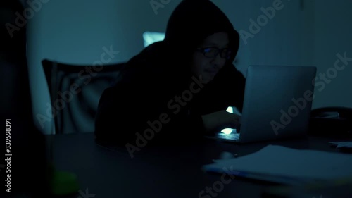 A computer programmer or hacker prints a code on a laptop keyboard to break into a secret organization system.
