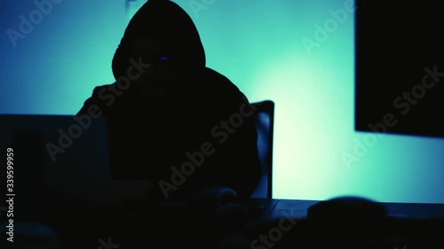 A computer programmer or hacker prints a code on a laptop keyboard to break into a secret organization system.