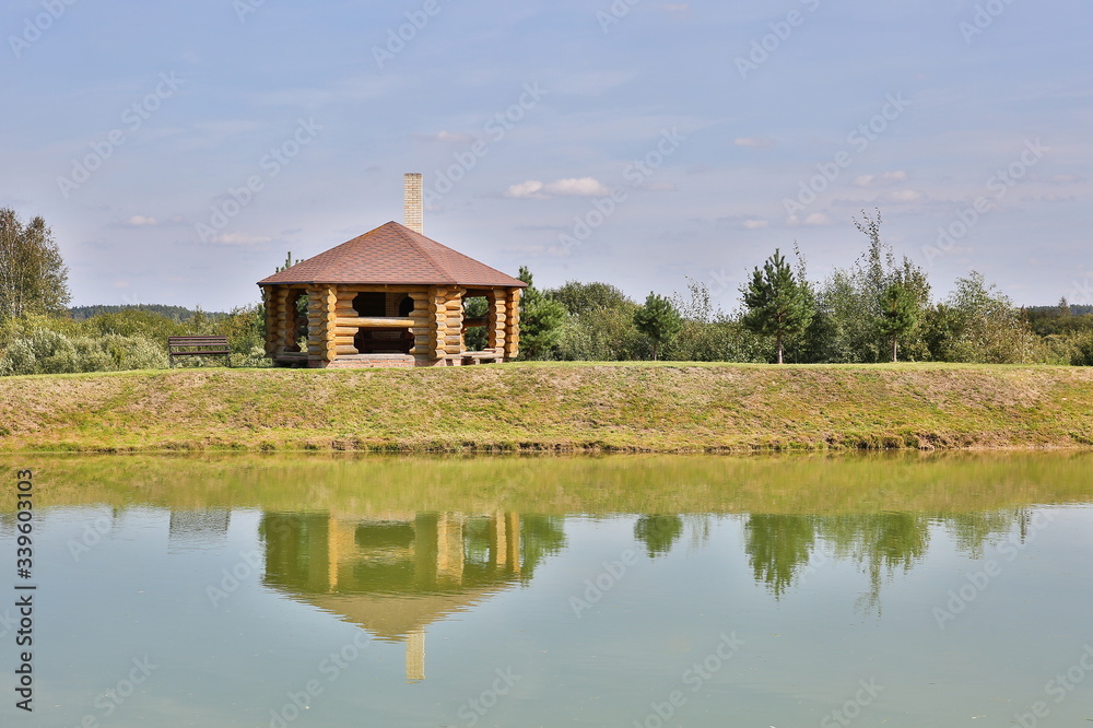 Fototapeta premium log house on the lake with reflection in summer