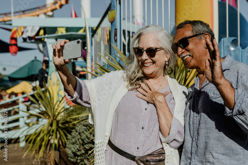 Senior couple taking a selfie in a theme park © rawpixel.com