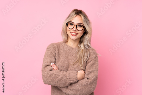 Quadro su tela Teenager blonde girl wearing a sweater over isolated pink background with glasse