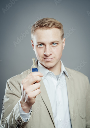 Cheerful corporate man holding key