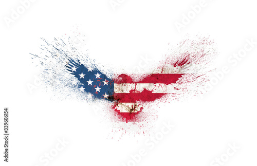 Usa grunge flag in the form of a silhouette of a flying eagle with spread wings with paint splatters isolated on a white. American flag in a shape of a silhouette of a flying eagle with paint splash.