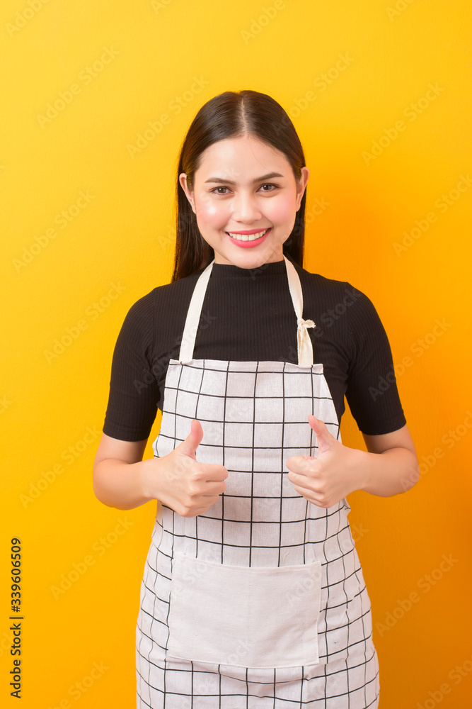 Happy female cook portrait on yellow background Happy female cook portrait on yellow background