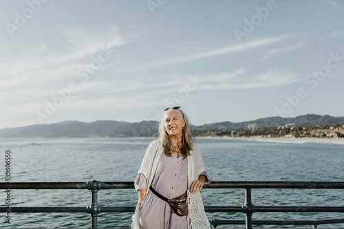 Smiling senior woman on the pier by the sea