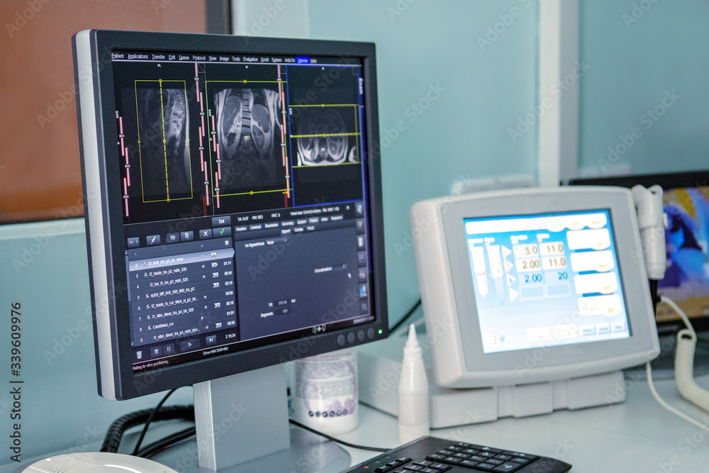 Naklejka premium The monitor shows the results of a lung scan, in the background the patient undergoes an MRI or CT scan.