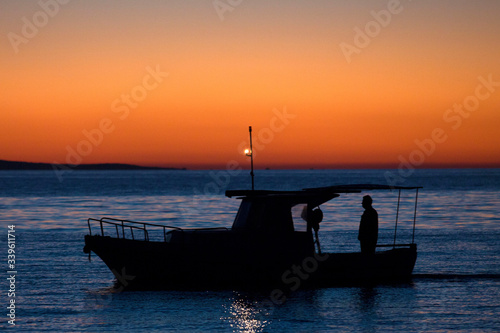 Silhouette of a fishermen sailing in the sunrise © SCPRO