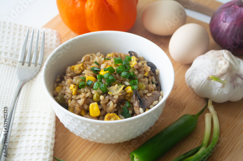Chinese style vegetarian egg fried rice with sweet corn, green peas, onions, garlic, mushrooms and scallions