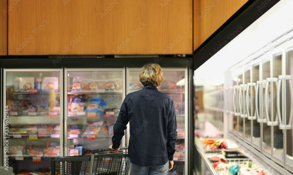 Man choosing frozen food from a supermarket freezer
