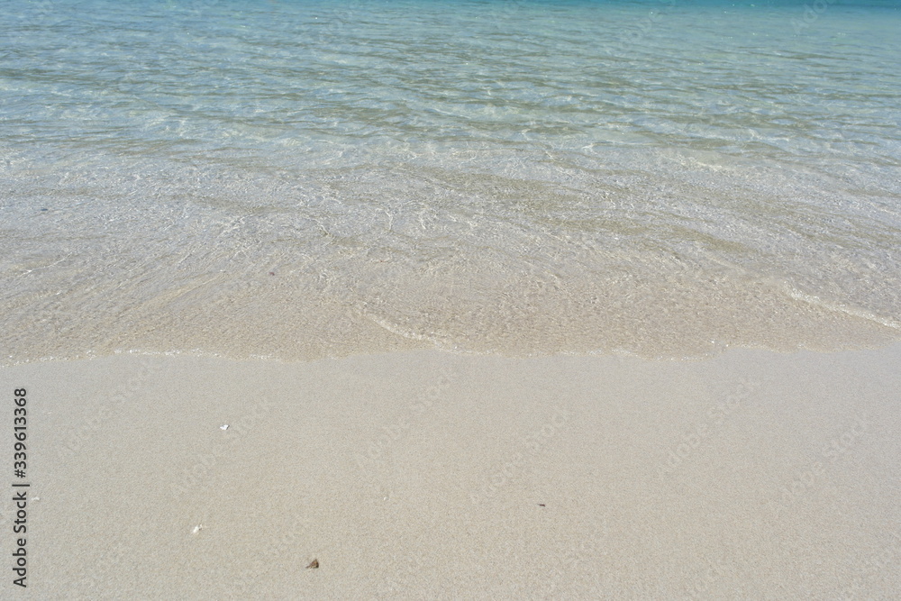 Transparent turquoise sea water, natural background. Sea surface in a turquoise lagoon. The texture of sea water. Summer and travel vacation concept.