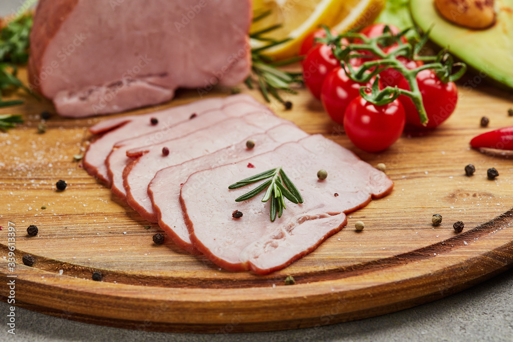 Sliced ham with spices, lettuce, avocado and tomatoes on wooden cutting board. Сold meat plate. Fresh prosciutto Sliced ham with spices, lettuce, avocado and tomatoes on wooden cutting board. Сold meat plate. Fresh prosciutto