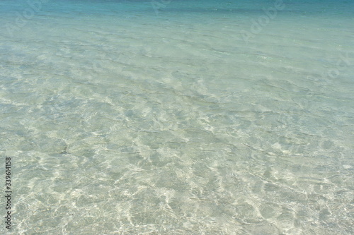 Fototapeta Naklejka Na Ścianę i Meble -  Transparent turquoise sea water, natural background. Sea surface in a turquoise lagoon. The texture of sea water. Summer and travel vacation concept.