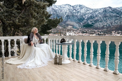 Beautyful bride sitting on a lake in winter mountances photo