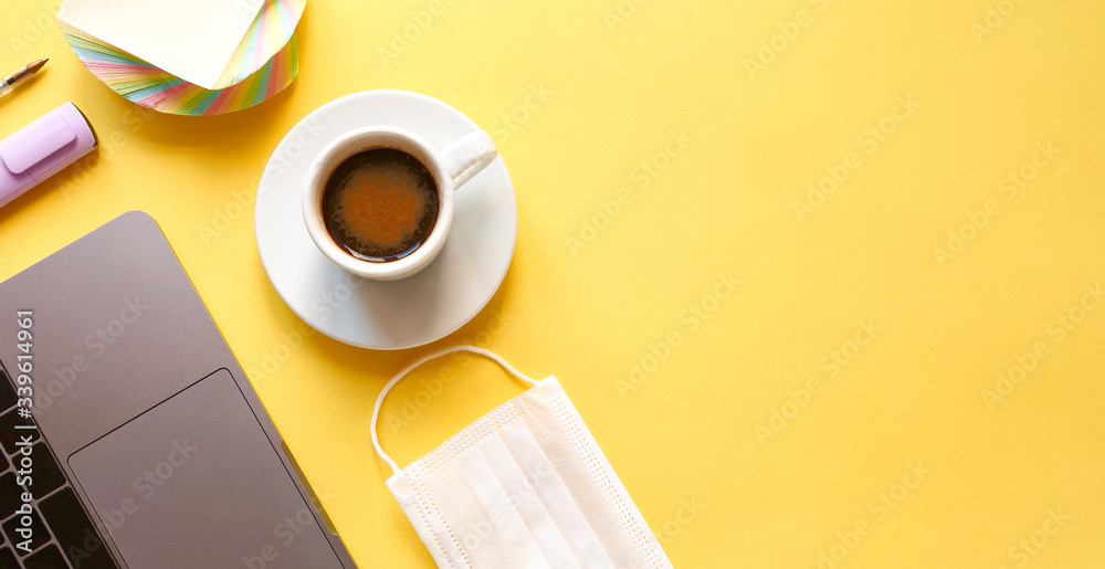 flat lay composition with laptop, pen, mask, coffee on yellow background. Concept remote study and work at home, telework, freelance, quarantine. Coffee break, office table. Copyspace, banner flat lay composition with laptop, pen, mask, coffee on yellow background. Concept remote study and work at home, telework, freelance, quarantine. Coffee break, office table. Copyspace, banner