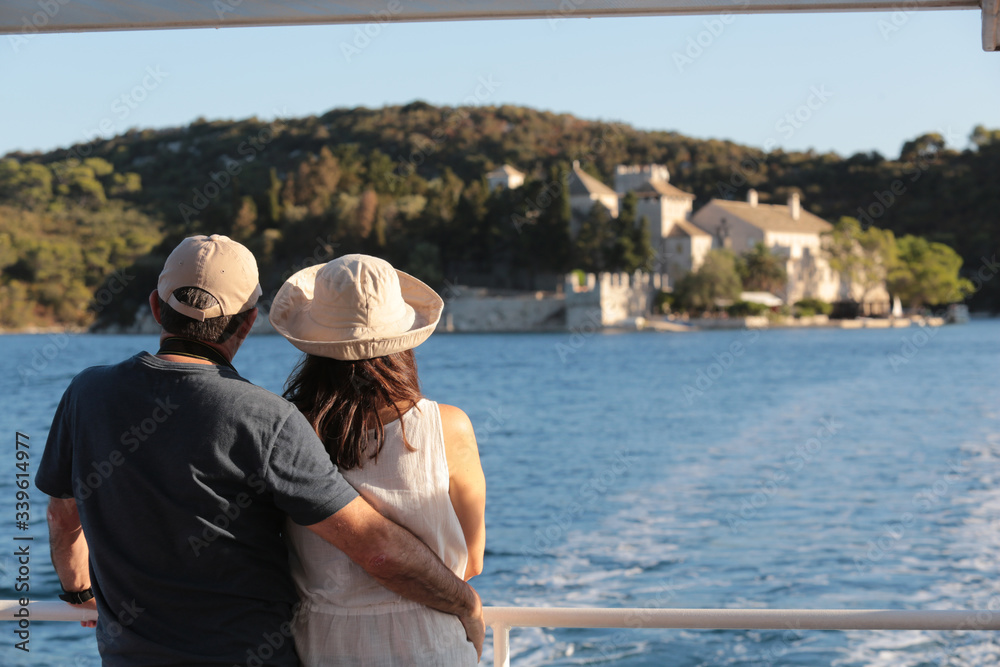 A cuddled couple on a ship looking into the sea landscape