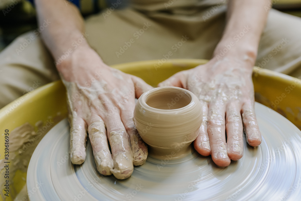 hands make a vase behind a potter's wheel. ceramics. pottery, macro shooting hands make a vase behind a potter's wheel. ceramics. pottery, macro shooting