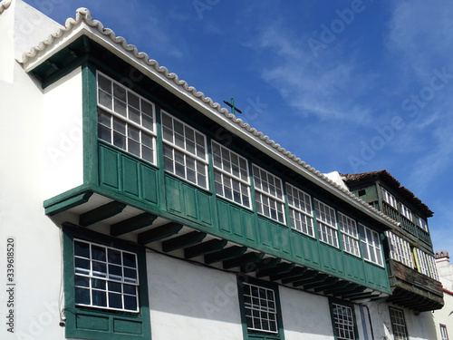 Historic traditional building with glazed enclosed balcony in the old city center of Santa Cruz. La Palma Island. Canary Islands. Spain.  