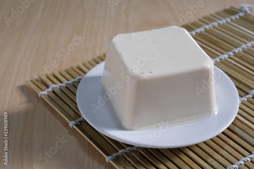 tofu or bean curd on white plate on wooden table