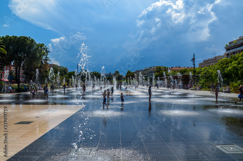 Water games on Promenade du Paillon in Nice. Water reflecting fountain surrounded by beautiful historic buildings. Nice, France photo