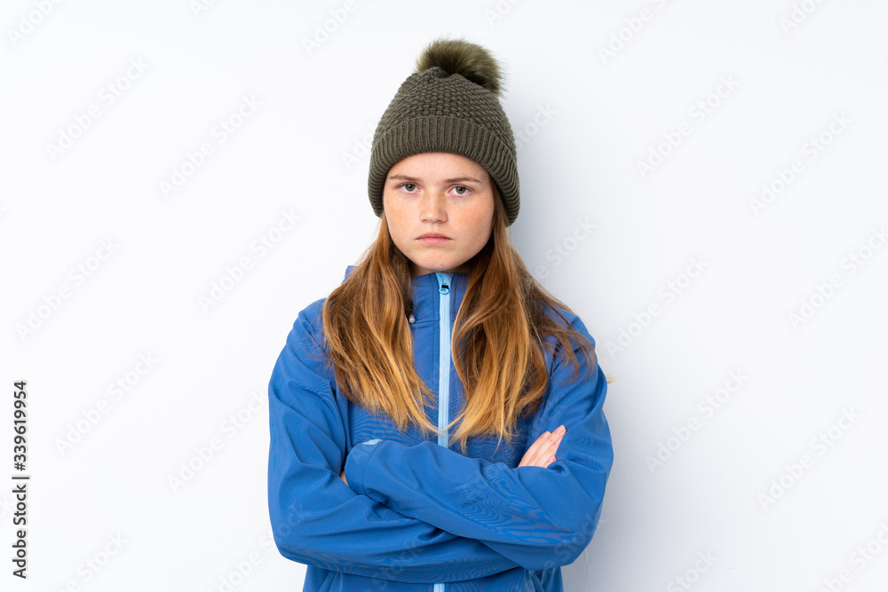 Ukrainian teenager girl with winter hat over isolated white background keeping arms crossed Ukrainian teenager girl with winter hat over isolated white background keeping arms crossed