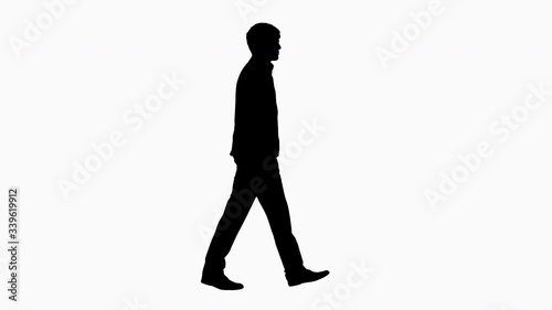 Silhouette Handsome business man walking with his hands in pockets.