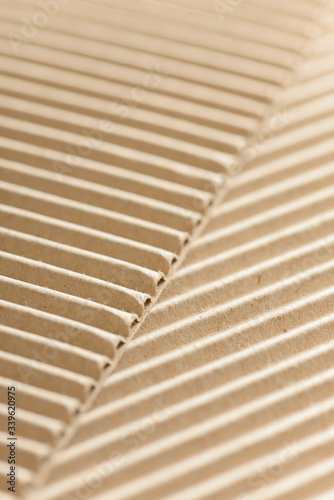 Carton or cardboard packing material. Texture of corrugated paper sheets made from cellulose. Supplies for creating boxes and packaging. Pasteboard background. Natural brown cardboard surface.