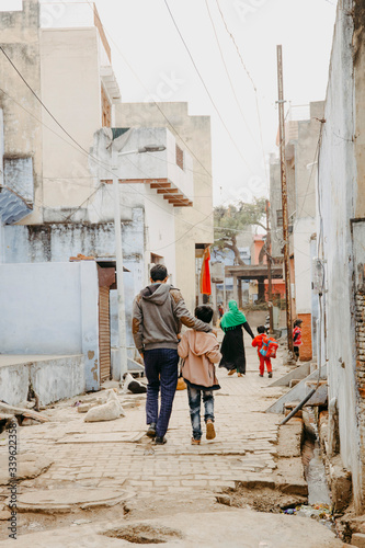 Father and son walking down the road in Agra, India © Dennis