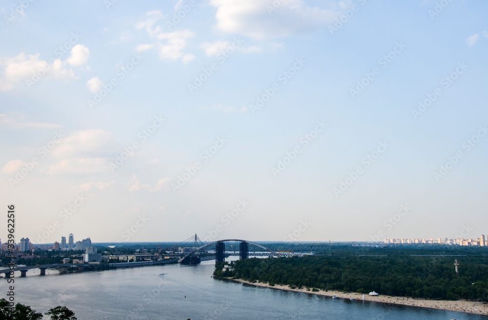 Panoramic view from new Pedestrian-Bicycle Bridge. Beautiful Dnipro River with bridges and residential houses at the background in the capital of Ukraine, Kyiv