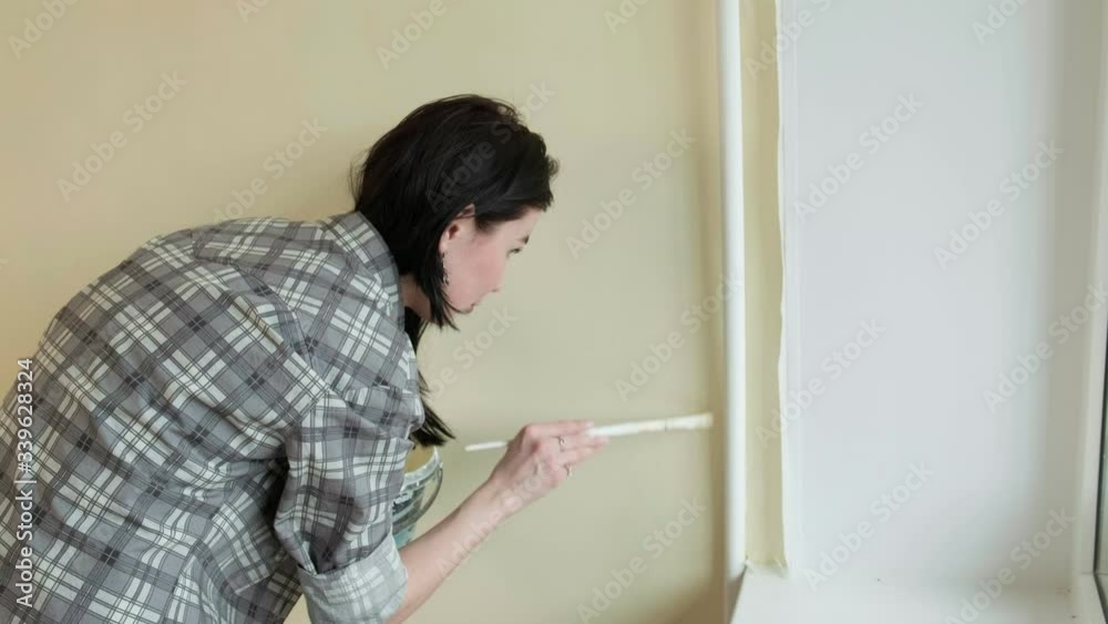 Female house painters paint the walls in the room. Female house painters paint the walls in the room.
