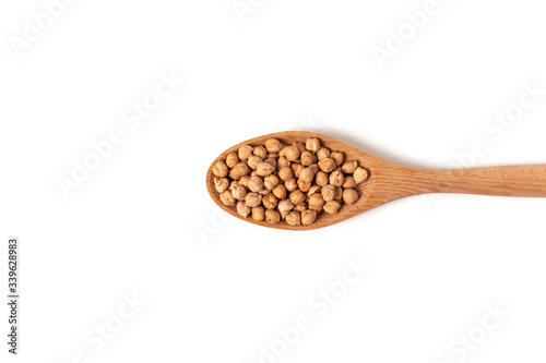 Dry organic chickpeas in a wooden spoon isolated on white background with space. Top view. 