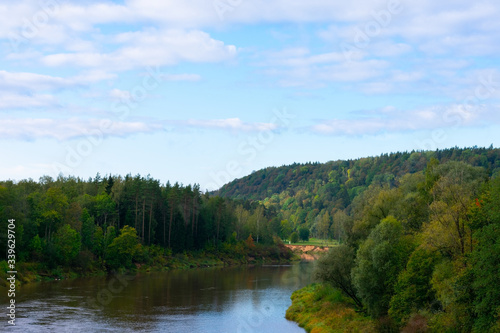 Picturesque landscape of deep river and european mixed forest. A lot of trees on shores