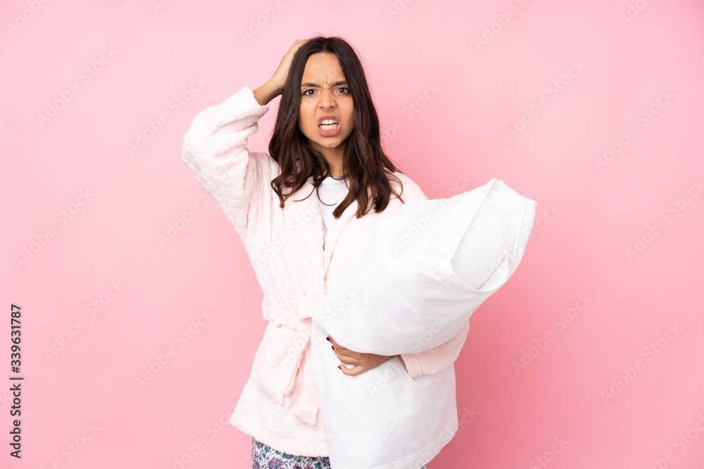 Young woman in pajamas isolated on pink background frustrated and takes hands on head Young woman in pajamas isolated on pink background frustrated and takes hands on head