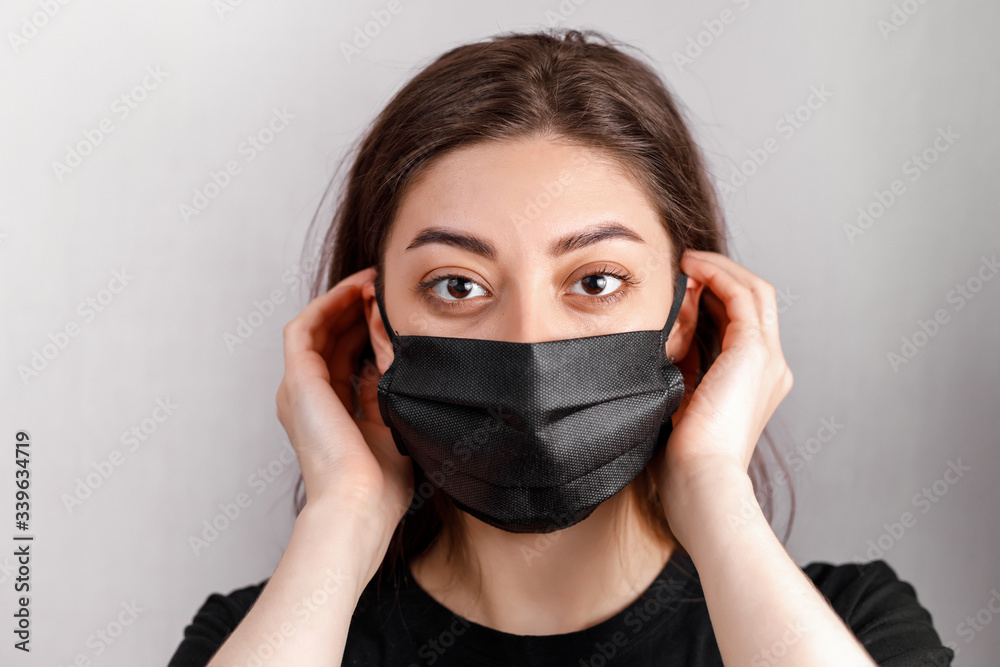 Studio portrait of young woman wearing a face mask, looking at camera, close up, isolated on white background Studio portrait of young woman wearing a face mask, looking at camera, close up, isolated on white background