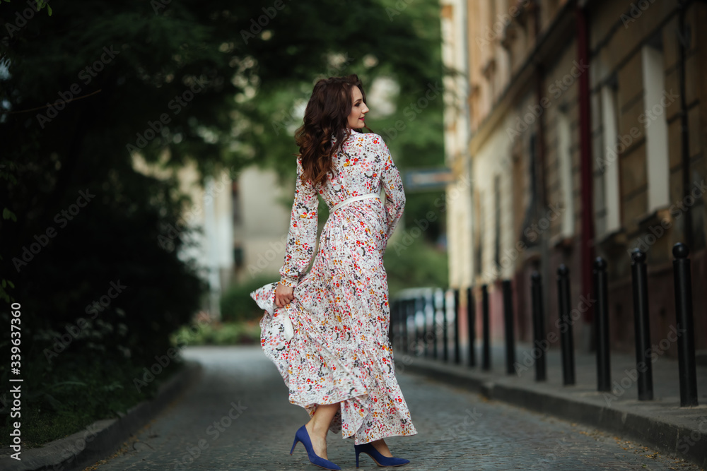 Naklejka premium Girl in a beautiful dress park in a flower