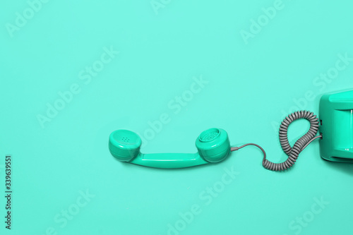 Old fashioned handset on neo mint green background. photo