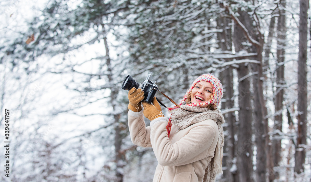 woman holding photo camera. taking picture in winter forest. Photographer photographing on snowy winter day. happy woman warm clothes fashion. winter travel vacation. stylish hipster traveler woman holding photo camera. taking picture in winter forest. Photographer photographing on snowy winter day. happy woman warm clothes fashion. winter travel vacation. stylish hipster traveler