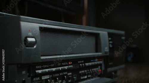 VHS video cassette is loaded and unloaded into the video recorder compartment photo
