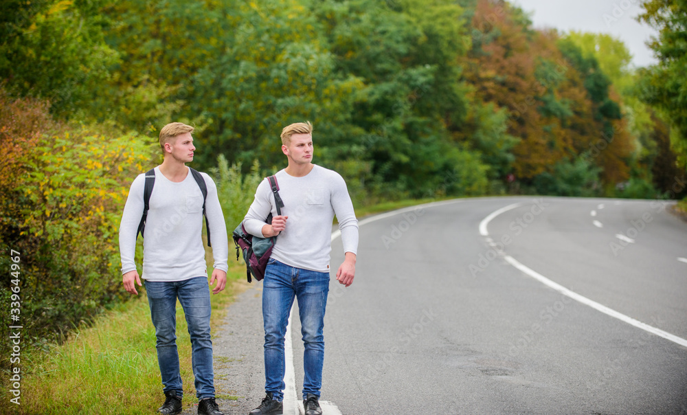 Go near edge of city. Travellers on their way. Friends hitchhikers travelling. Company friends travelers hitchhiking at road nature background. Begin great adventure in your life with hitchhiking