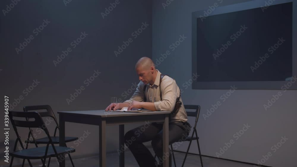 A policeman is engaged in paperwork. Long shot