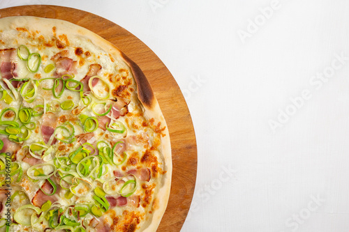 italian pizza with bacon and onions on a white plate