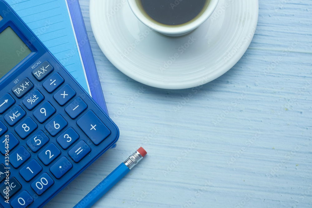 calculator, notepad and tea on wooden table calculator, notepad and tea on wooden table