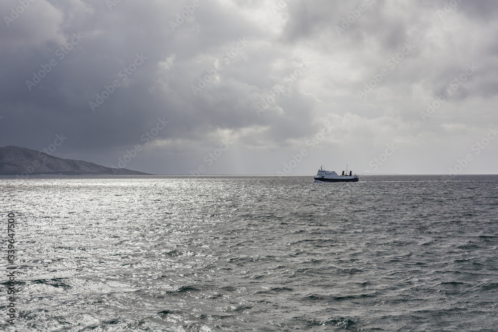 ship sailing on the blue water of the norwegian fjords in polar day, midnight sun