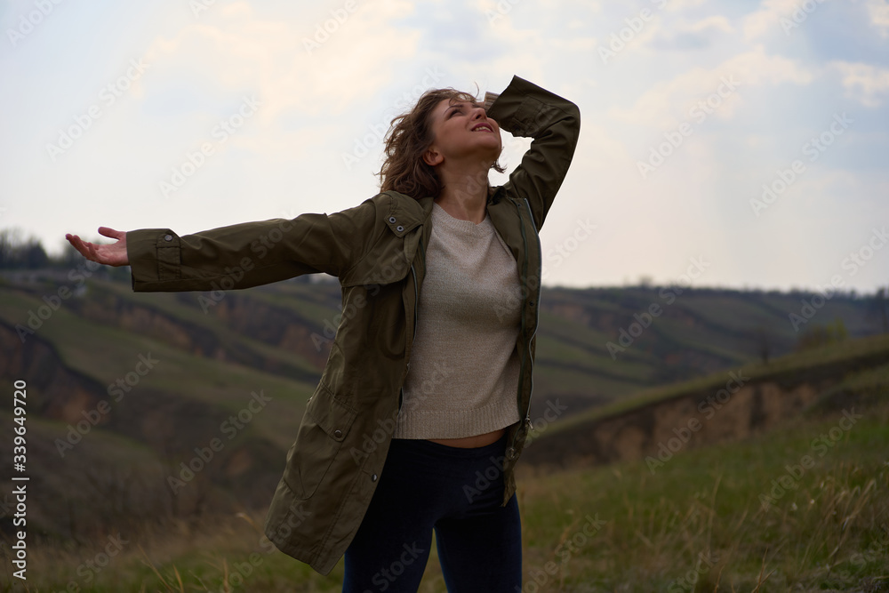 Alone girl on beautiful mountain view feeling free with wind  and sky. Isolated woman on nature background, freedom, post apocalypse