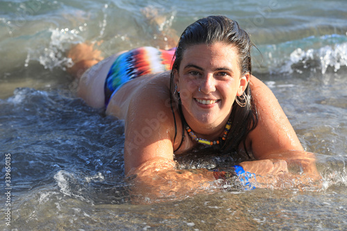 mujer joven sonriente bañandose en la playa toples almería 4M0A6202-as20 photo