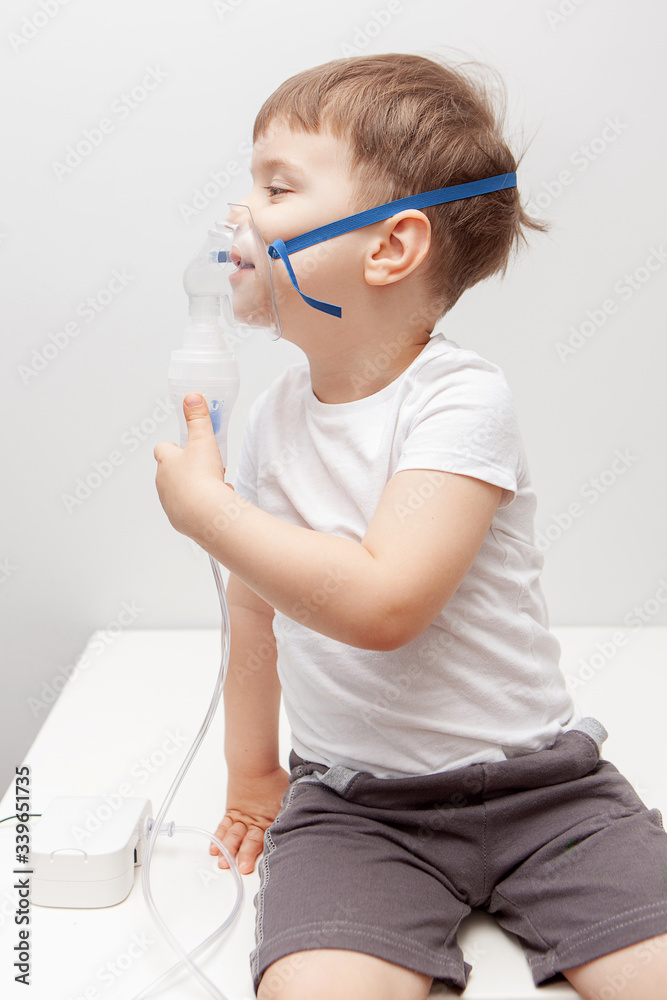 The boy makes inhalations. Treatment at home. Disease prevention