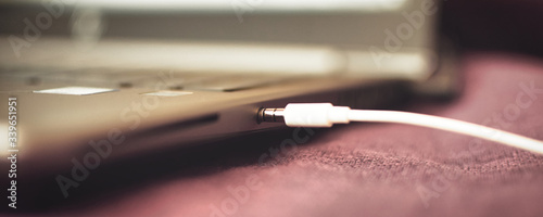close up of a headphones cable connecting to a laptop