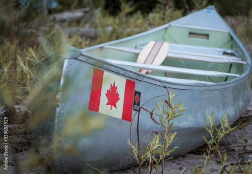 Obraz na płótnie Canoe on beach with Canadian flag w salonie