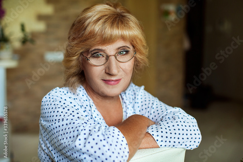 vision, age and people concept - portrait of happy blonde senior woman in glasses in home