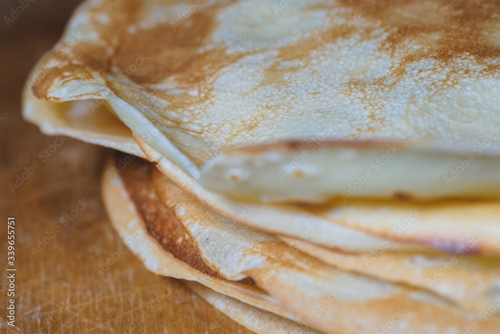 Close-up of stacked freshly baked pancakes on a wooden board